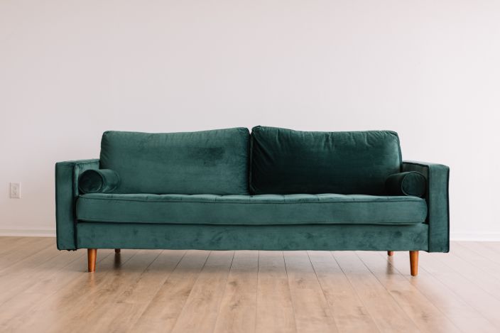 Dark green four seater sofa in a neutral room